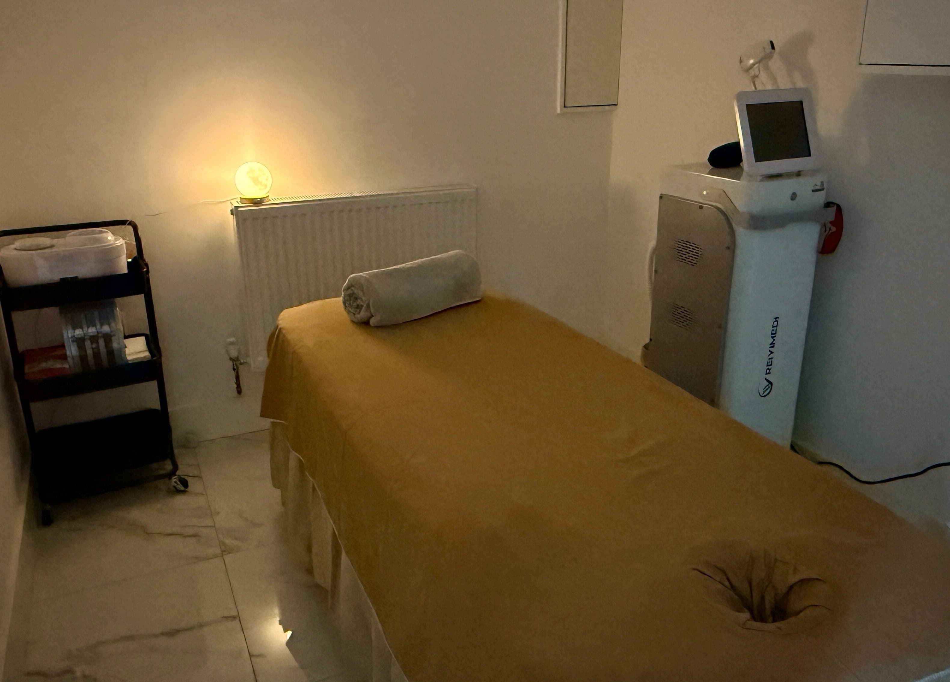 Cozy treatment room at Abby Nails Leyton, London, England, GB featuring a massage table and warm lighting.