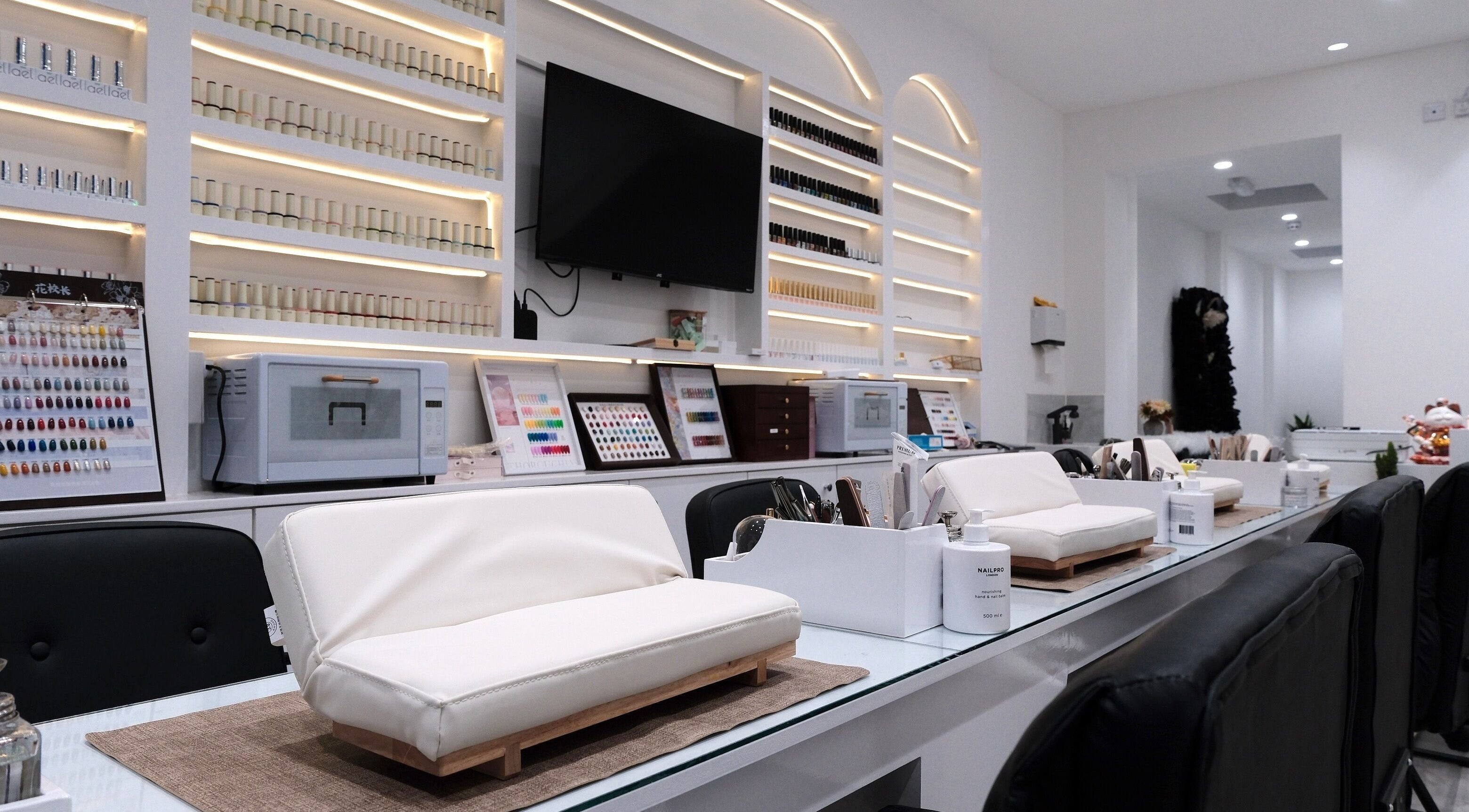 Modern interior of Abby Nails Leyton, London, England, GB, showcasing elegant nail stations and polish displays.