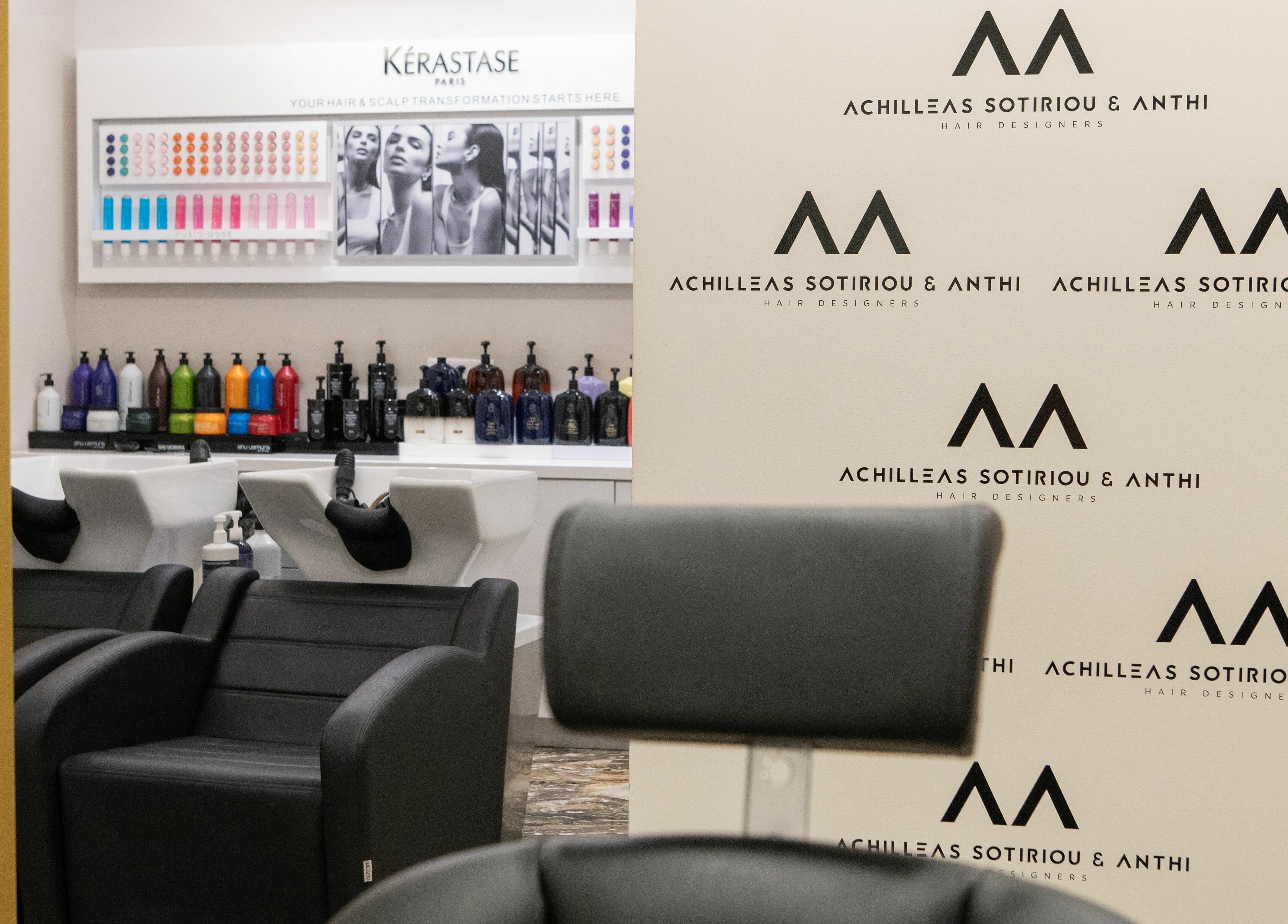 Κομψές καρέκλες σε ACHILLEAS SOTIRIOY & ANTHI, Αθήνα, GR με προϊόντα περιποίησης στο παρασκήνιο.