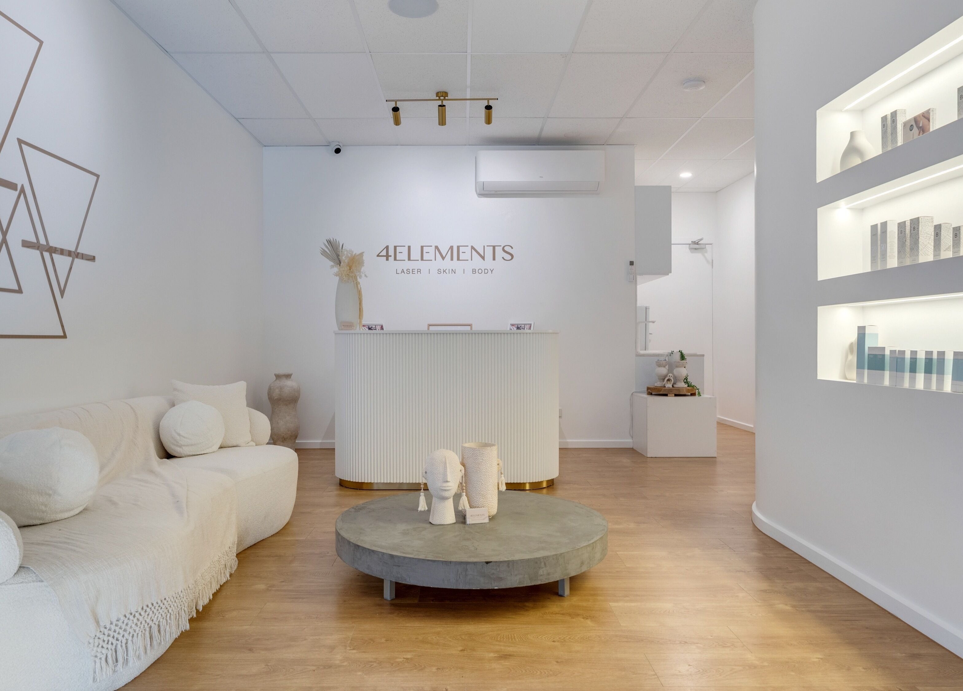 Elegant reception area of 4 Elements Clinic in Melbourne, Victoria, AU featuring a cozy sofa and minimal decor.