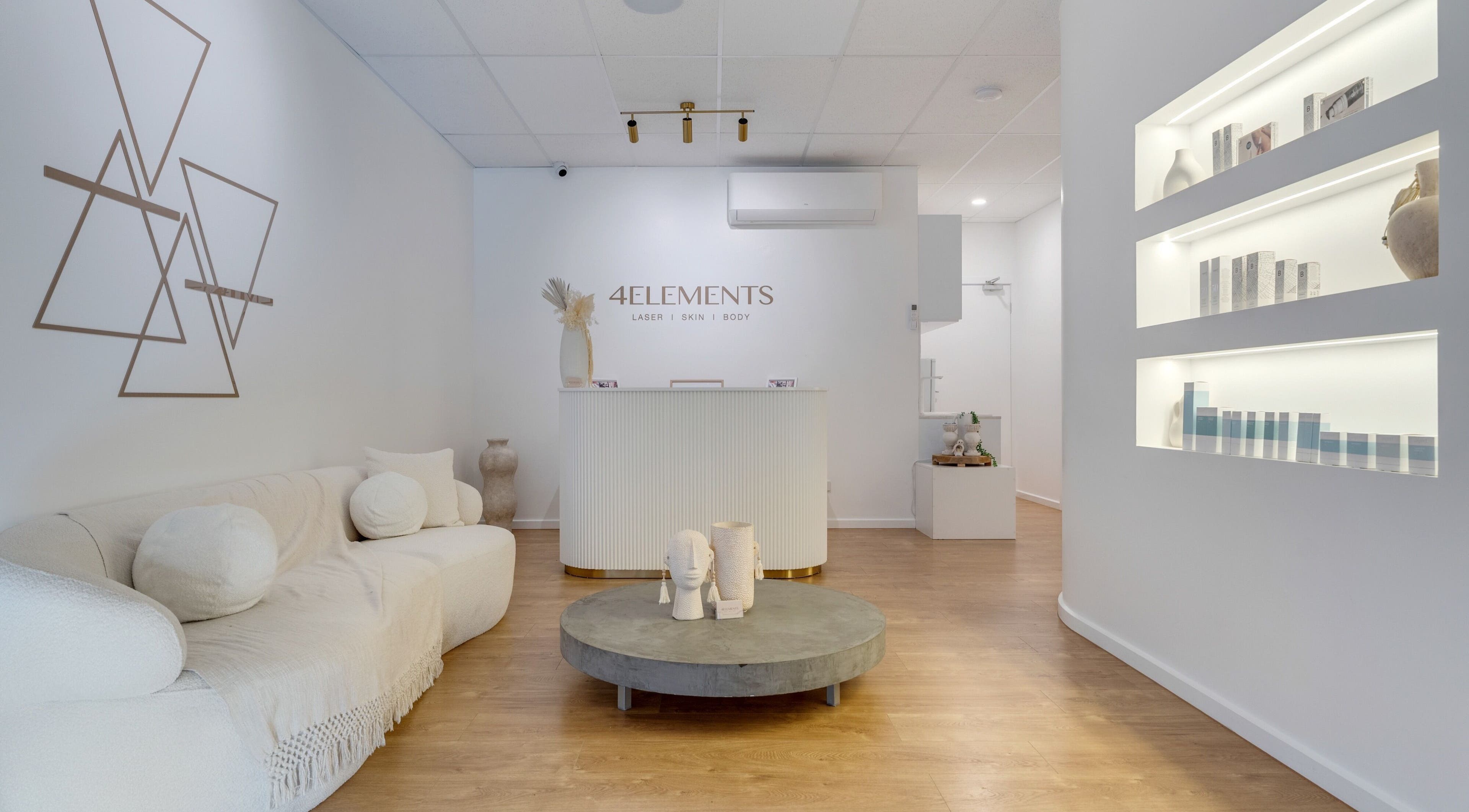 Elegant reception area of 4 Elements Clinic in Melbourne, Victoria, AU featuring a cozy sofa and minimal decor.