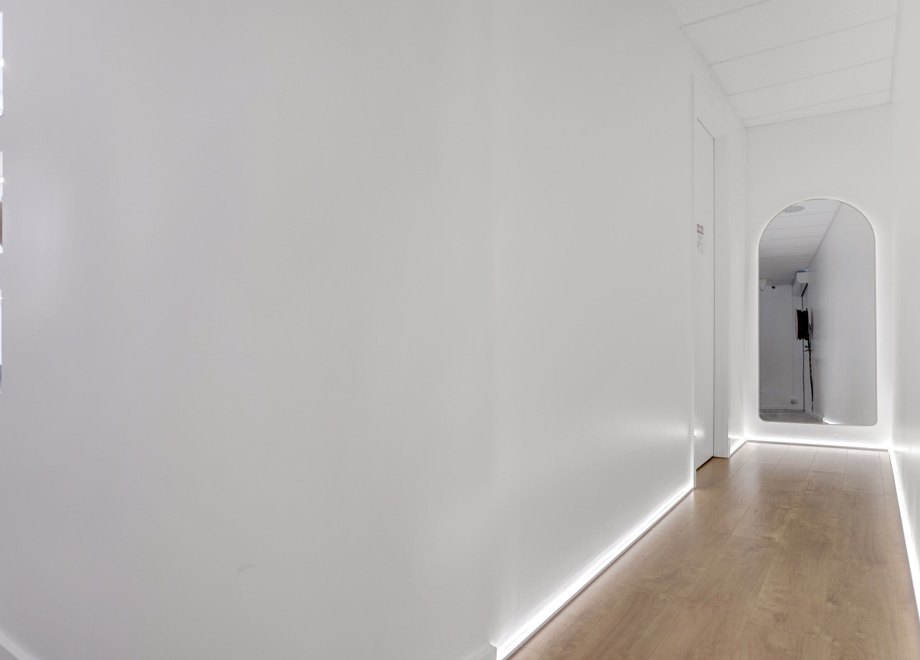 Minimalist hallway with illuminated shelves at 4 Elements Clinic, Melbourne, Victoria, AU.