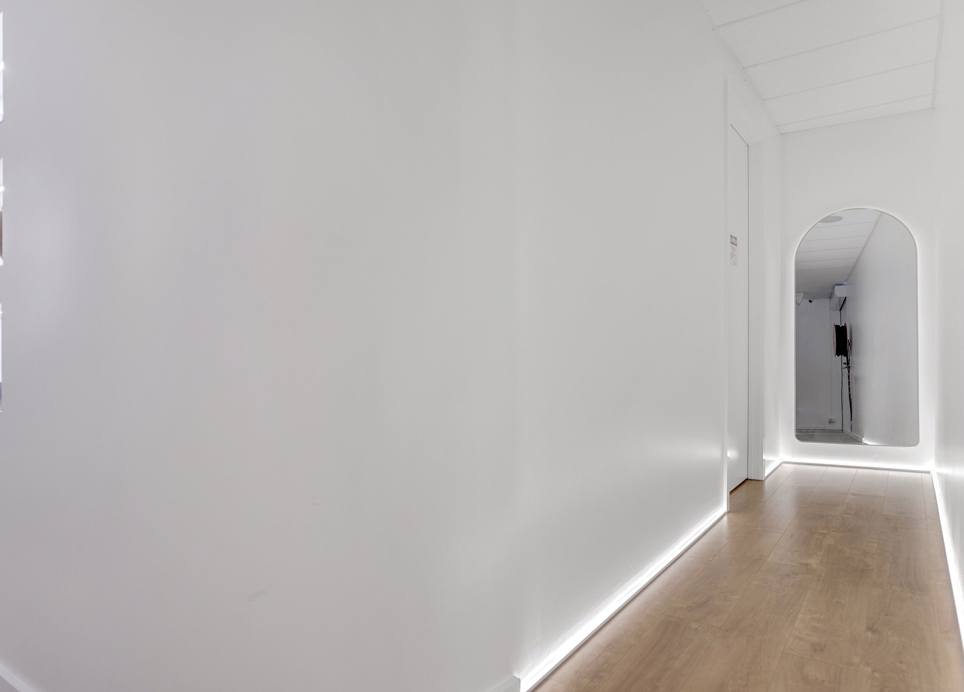 Minimalist hallway with illuminated shelves at 4 Elements Clinic, Melbourne, Victoria, AU.