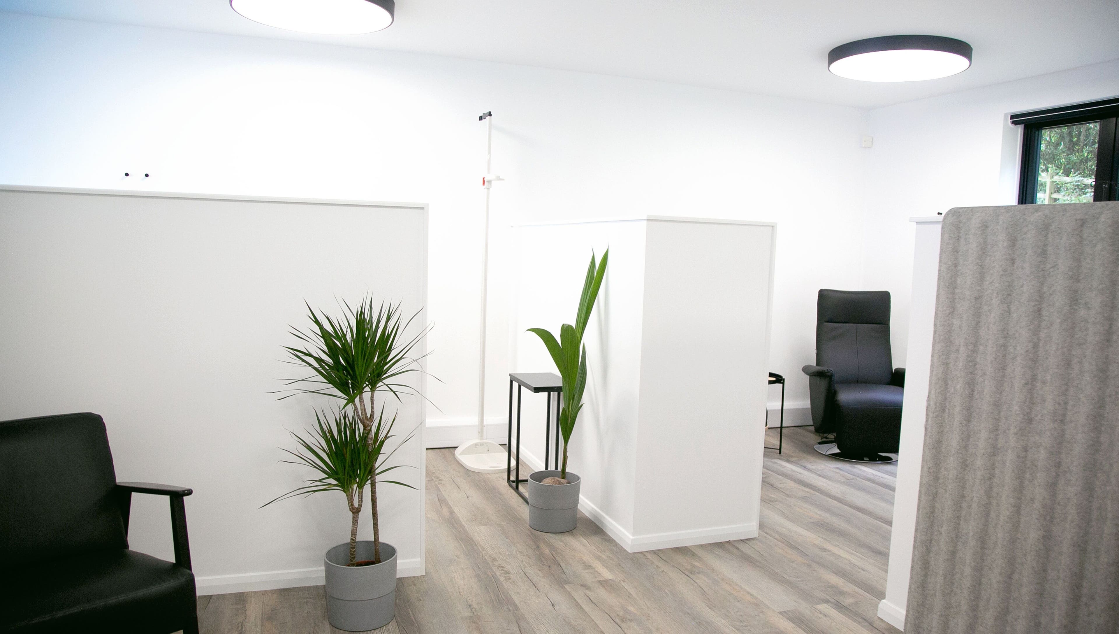 Modern relaxation space at NutriZen Wellness Centre in Wolverton, England, featuring sleek chairs and plants.