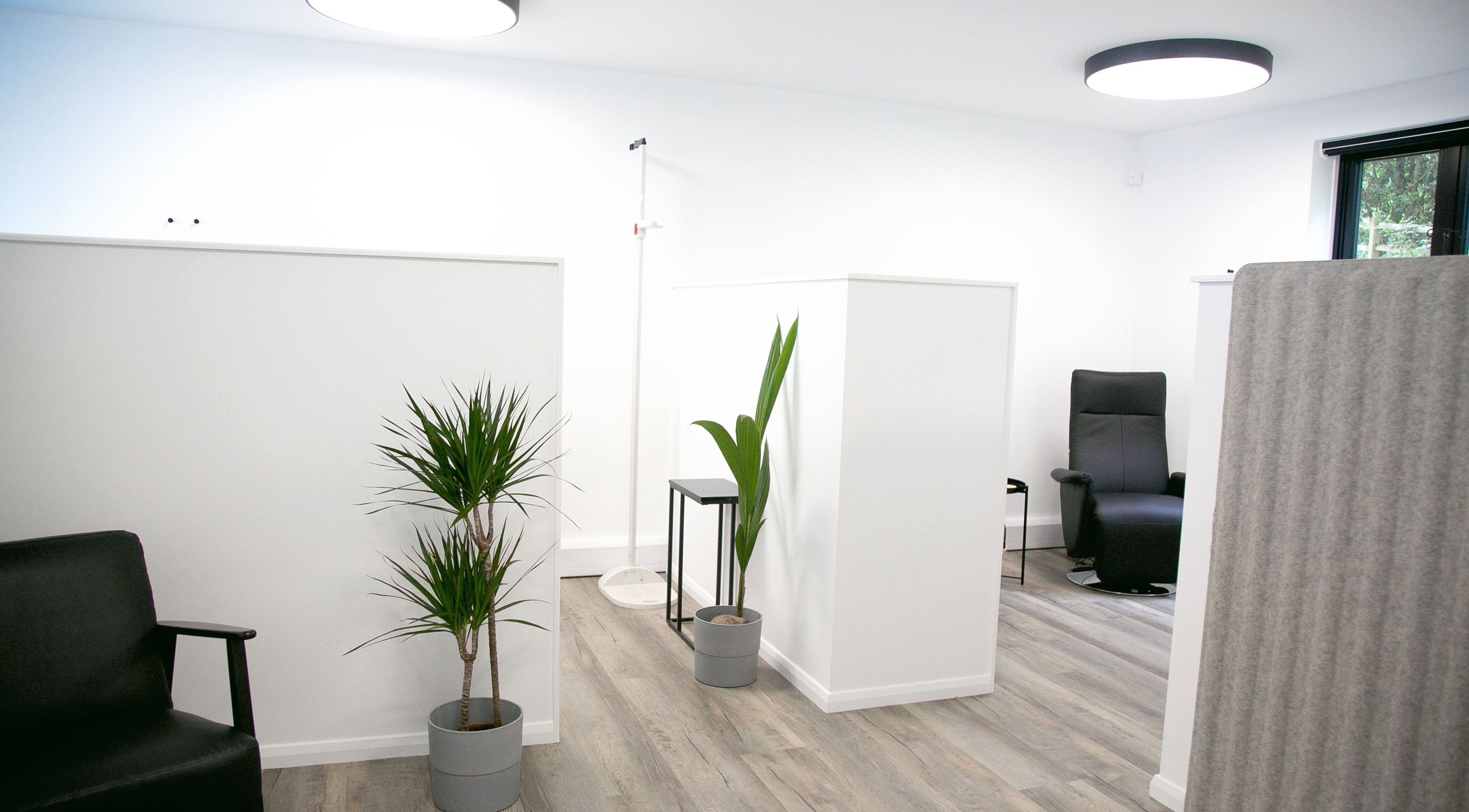 Modern relaxation space at NutriZen Wellness Centre in Wolverton, England, featuring sleek chairs and plants.