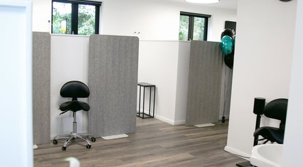 Modern treatment area at NutriZen Wellness Centre, Wolverton, England, GB, featuring minimalist design and seating.