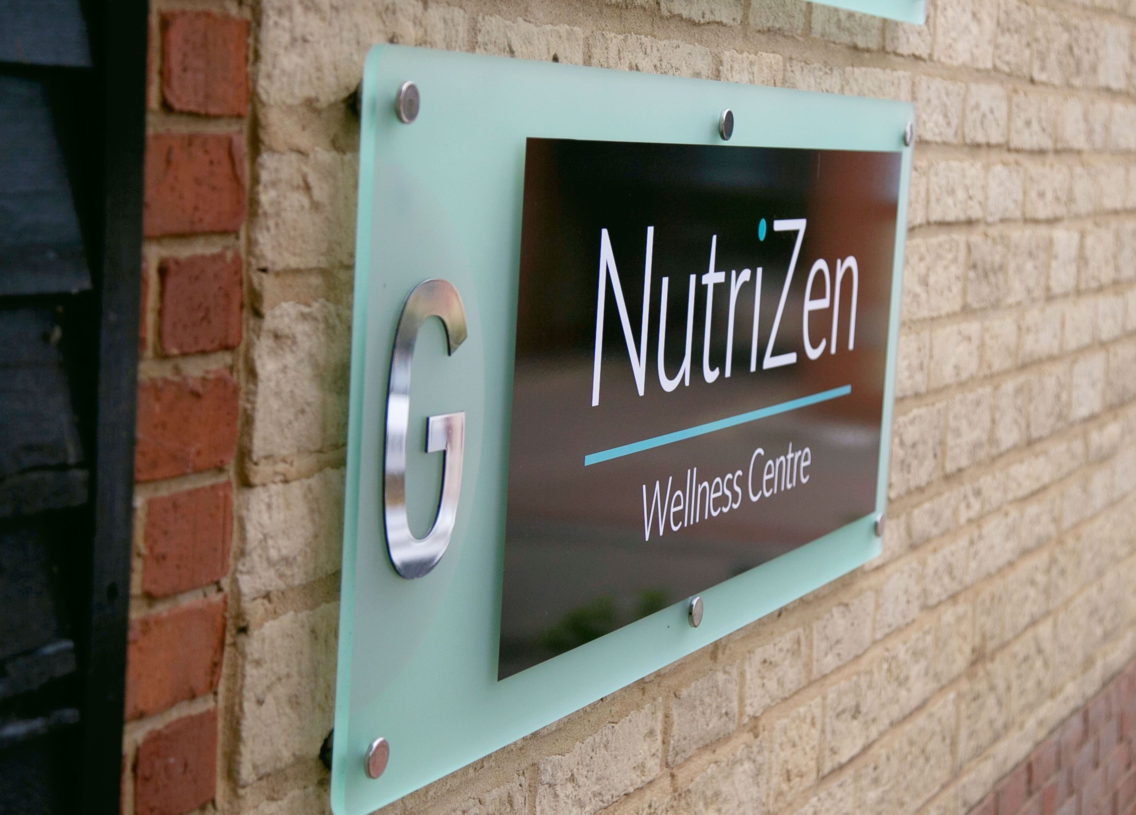 Exterior sign of NutriZen Wellness Centre, Wolverton, England, GB on a brick wall.