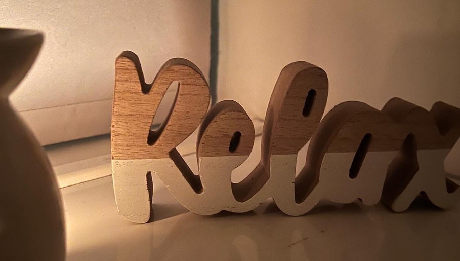 Wooden 'Relax' sign at AJ Massage, London, England, GB, creating a calm ambiance.