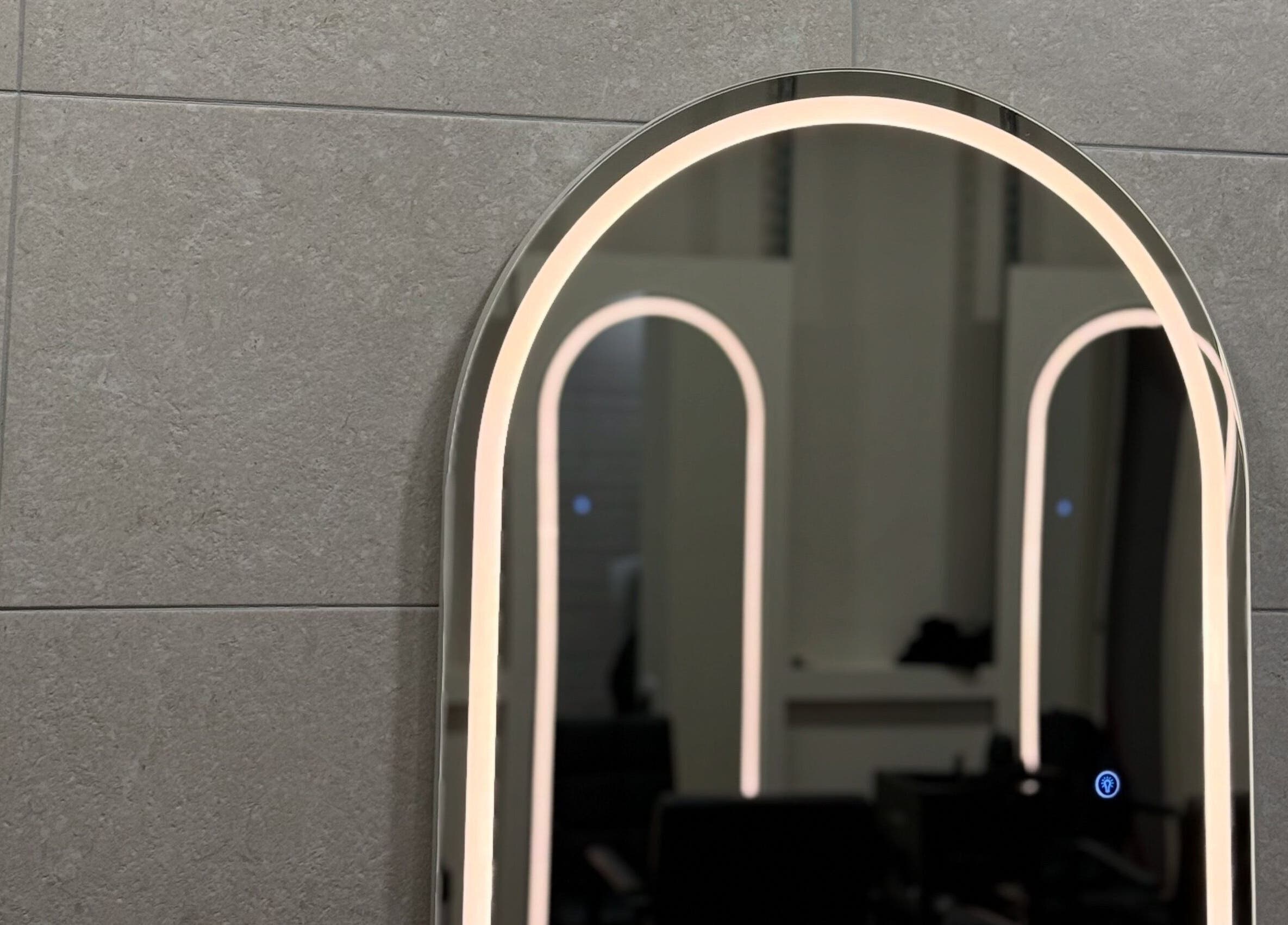 Illuminated arched mirror at Autumn & Easton, Glasgow, Scotland, GB enhances a sleek modern design.