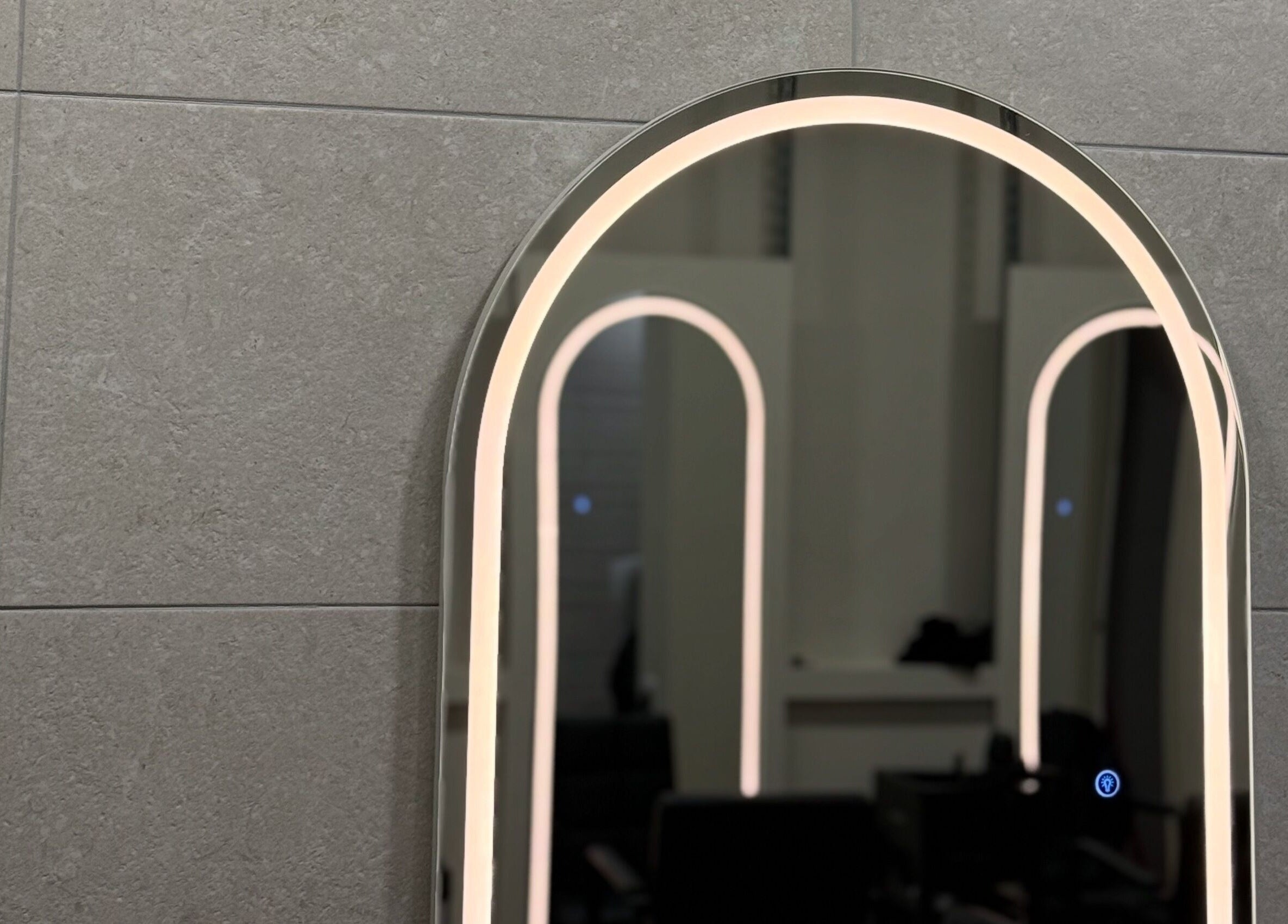 Illuminated arched mirror at Autumn & Easton, Glasgow, Scotland, GB enhances a sleek modern design.