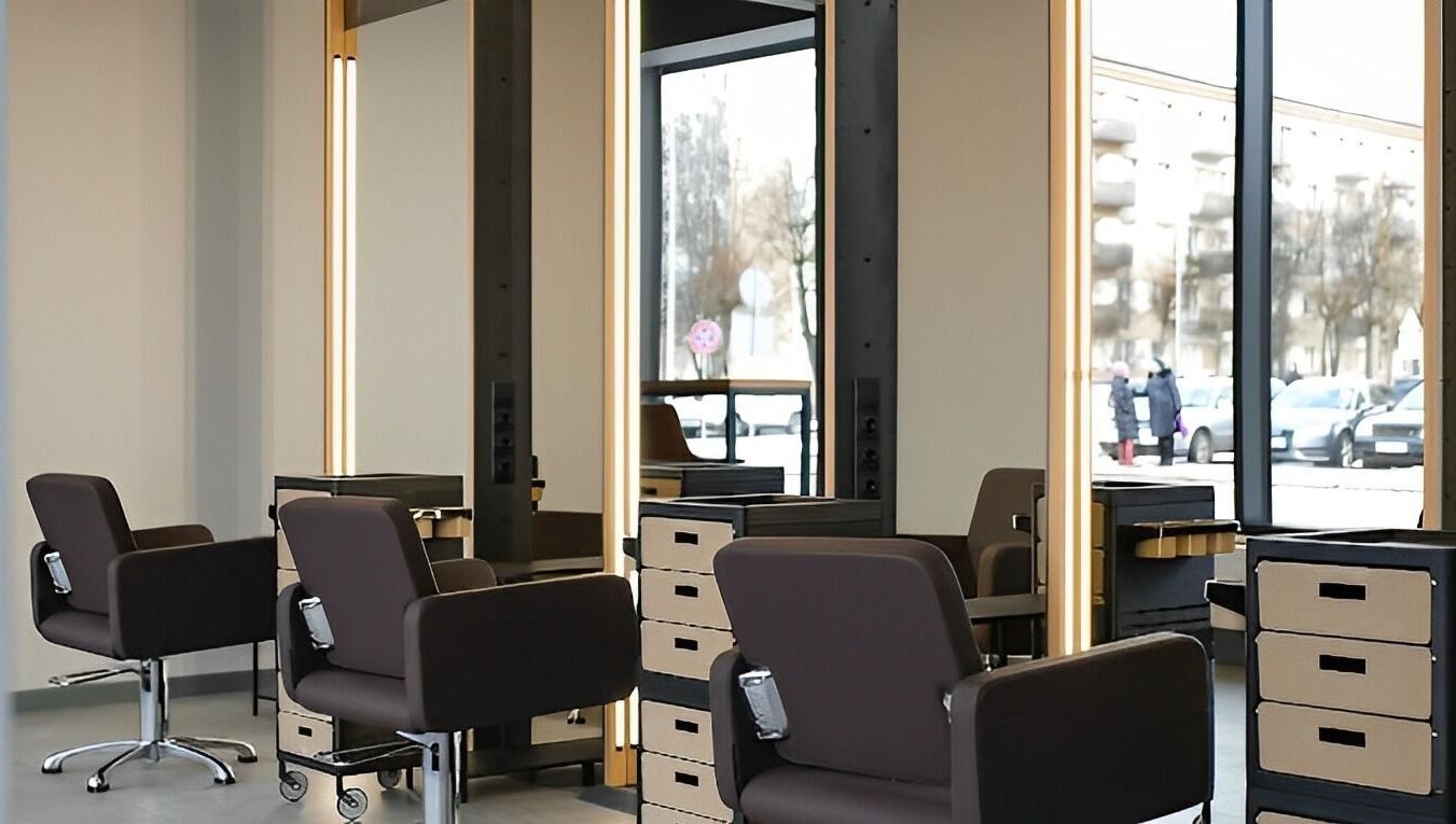 Modern salon stations at Skaistuma ēra in Jelgava, LV, featuring sleek chairs and mirrors for a luxurious experience.