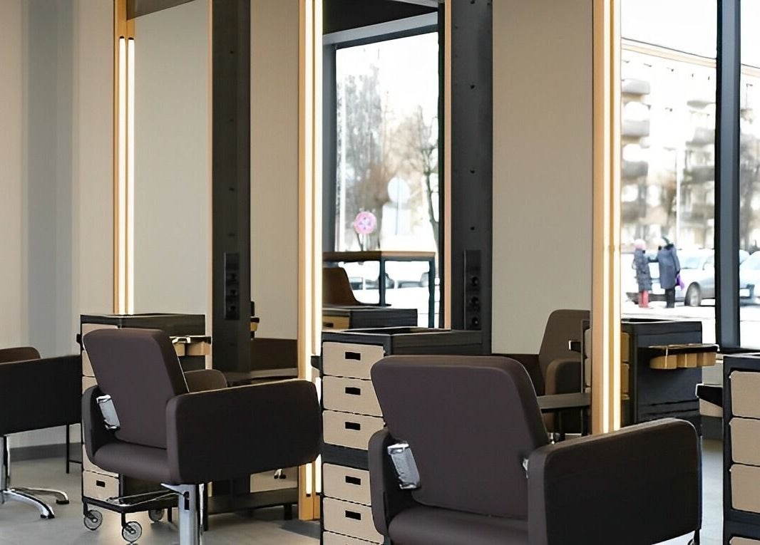 Modern salon stations at Skaistuma ēra in Jelgava, LV, featuring sleek chairs and mirrors for a luxurious experience.