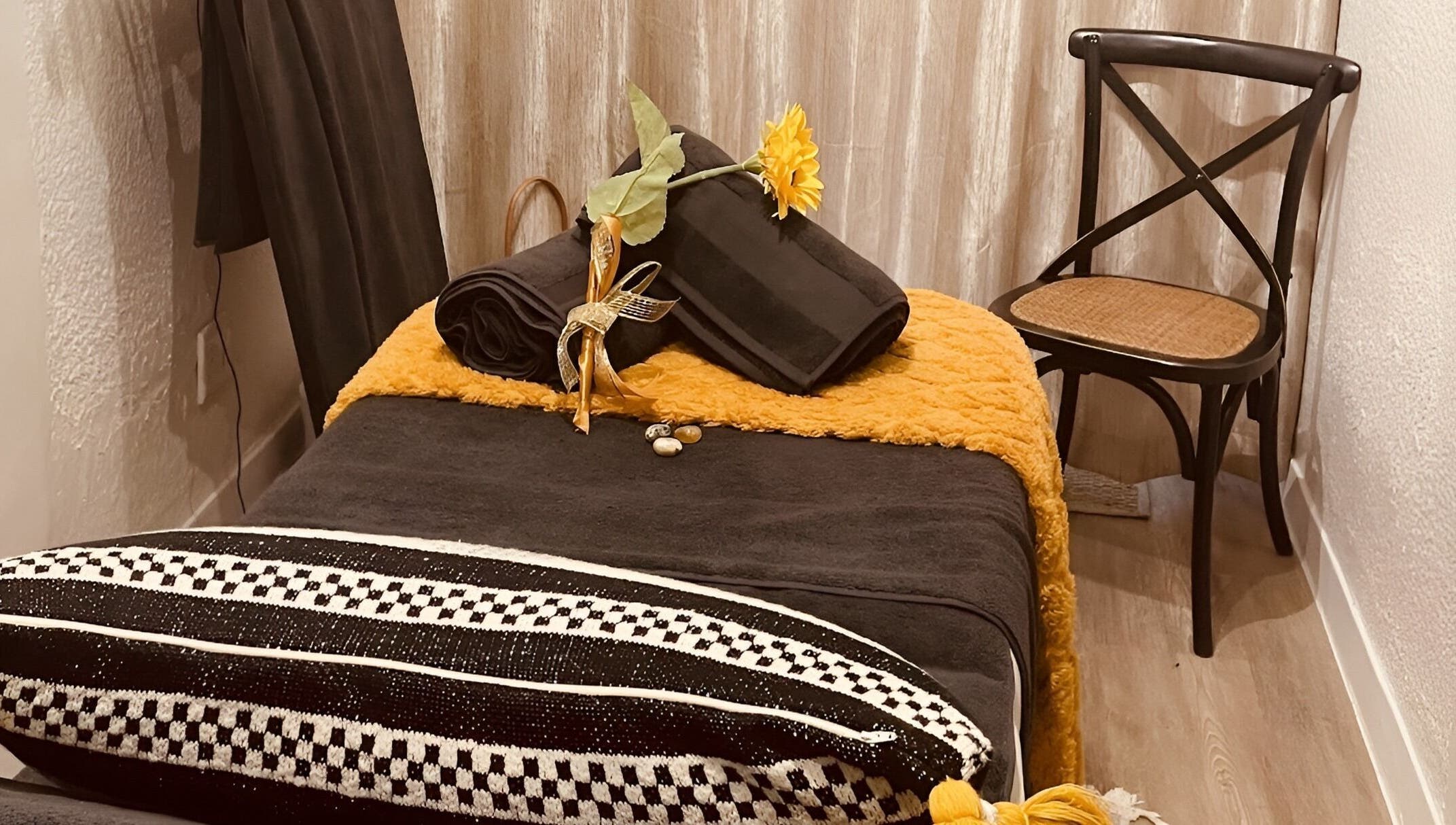 Relaxing spa setting at Sana Salon, Cape Town, Western Cape, ZA, featuring a plush black towel and sunflower decor.