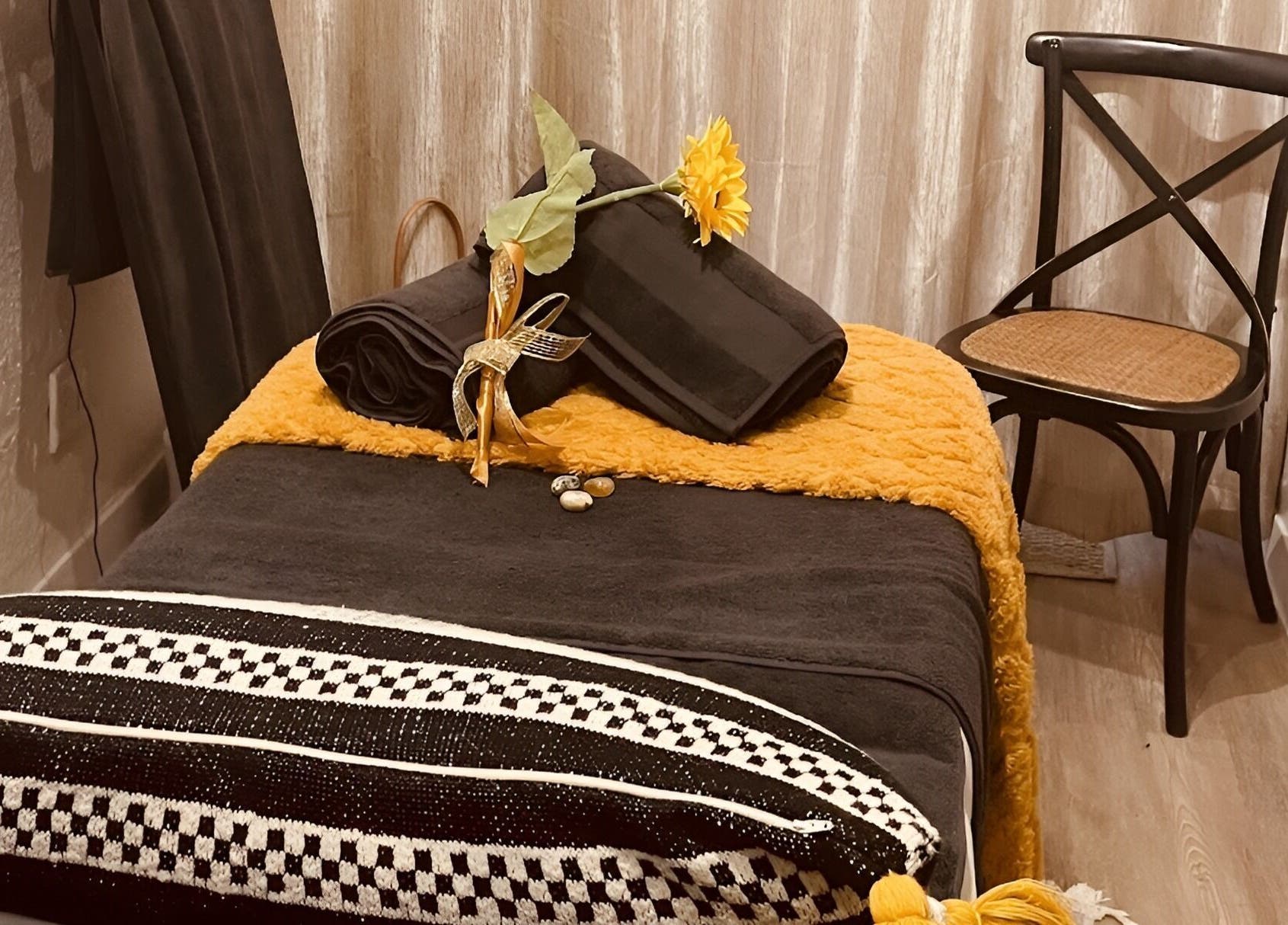 Relaxing spa setting at Sana Salon, Cape Town, Western Cape, ZA, featuring a plush black towel and sunflower decor.