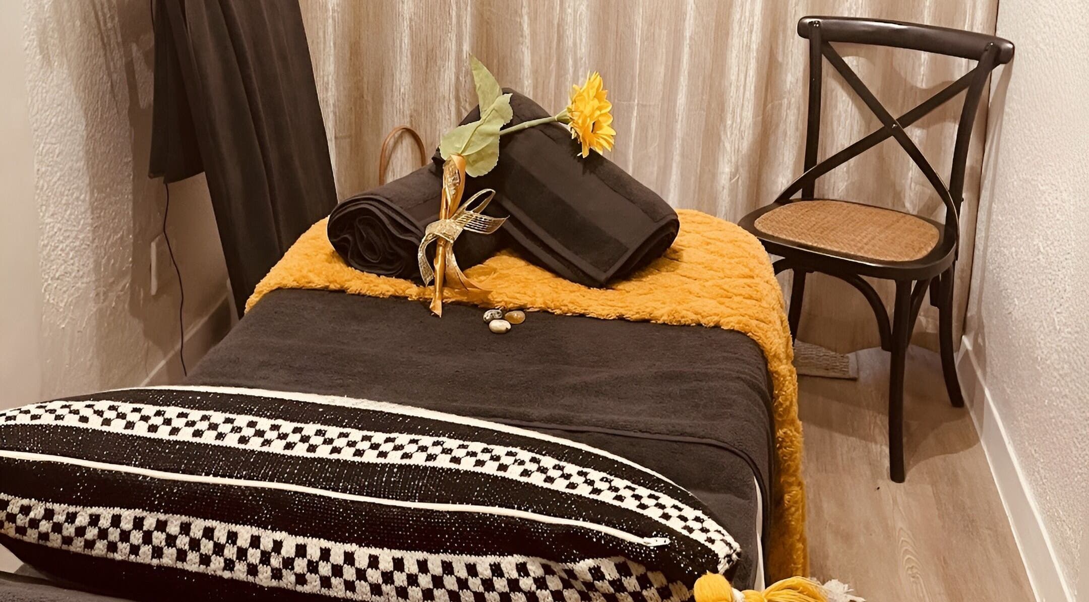 Relaxing spa setting at Sana Salon, Cape Town, Western Cape, ZA, featuring a plush black towel and sunflower decor.