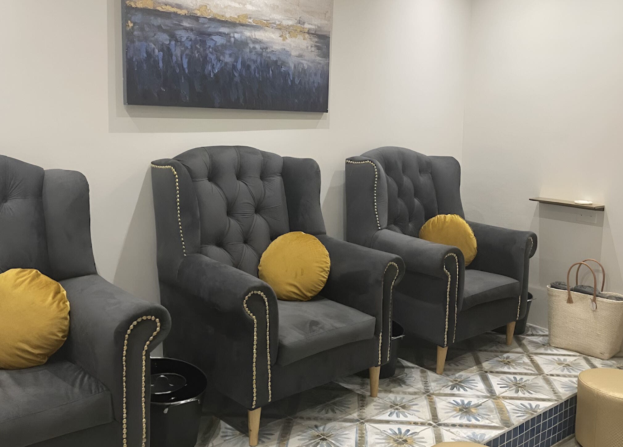 Luxurious seating area at Sana Salon in Cape Town, Western Cape, ZA, featuring plush grey chairs and art.