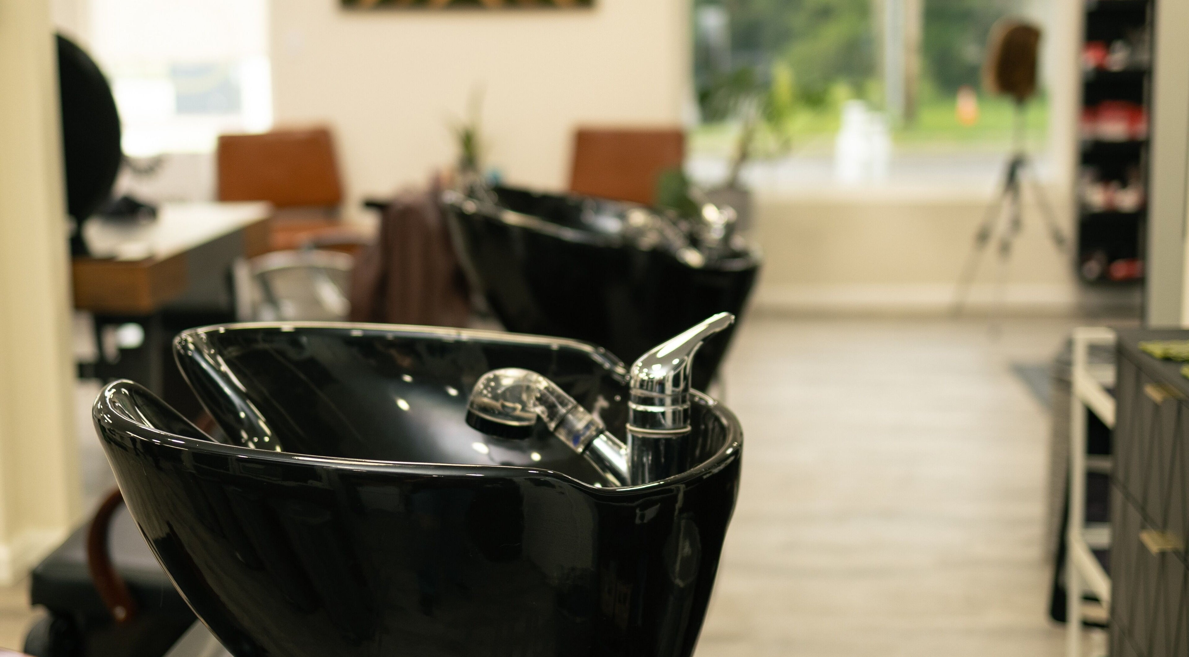 Modern washbasins at Sacred Beauty, Maryville, Illinois, US provide a sleek, inviting atmosphere for salon guests.