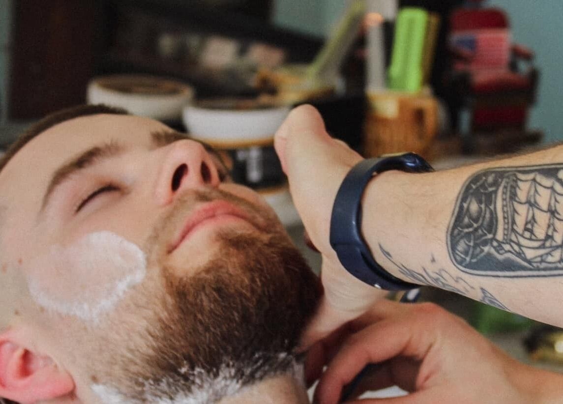 Klant ontspant tijdens scheerbeurt bij Retro 36 Barbershop, Veldhoven, Noord-Brabant, NL.