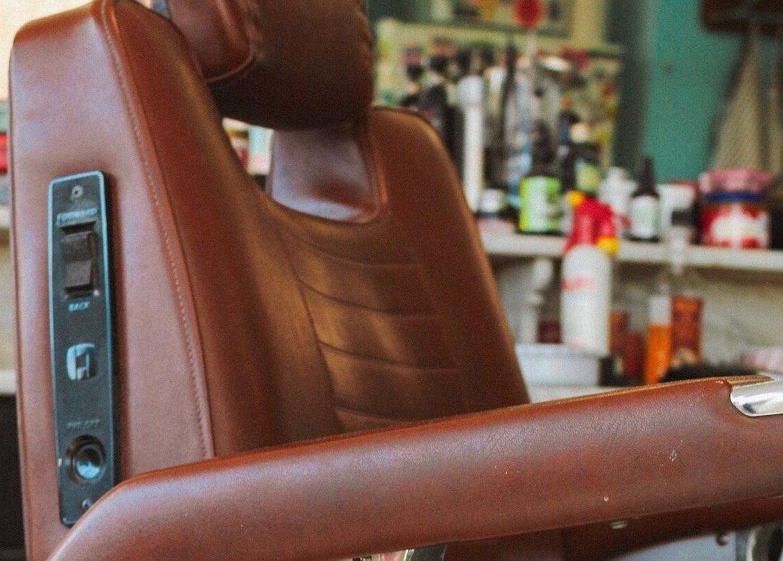 Klassieke kapperstoel bij Retro 36 Barbershop, Veldhoven, Noord-Brabant, NL, omgeven door producten.