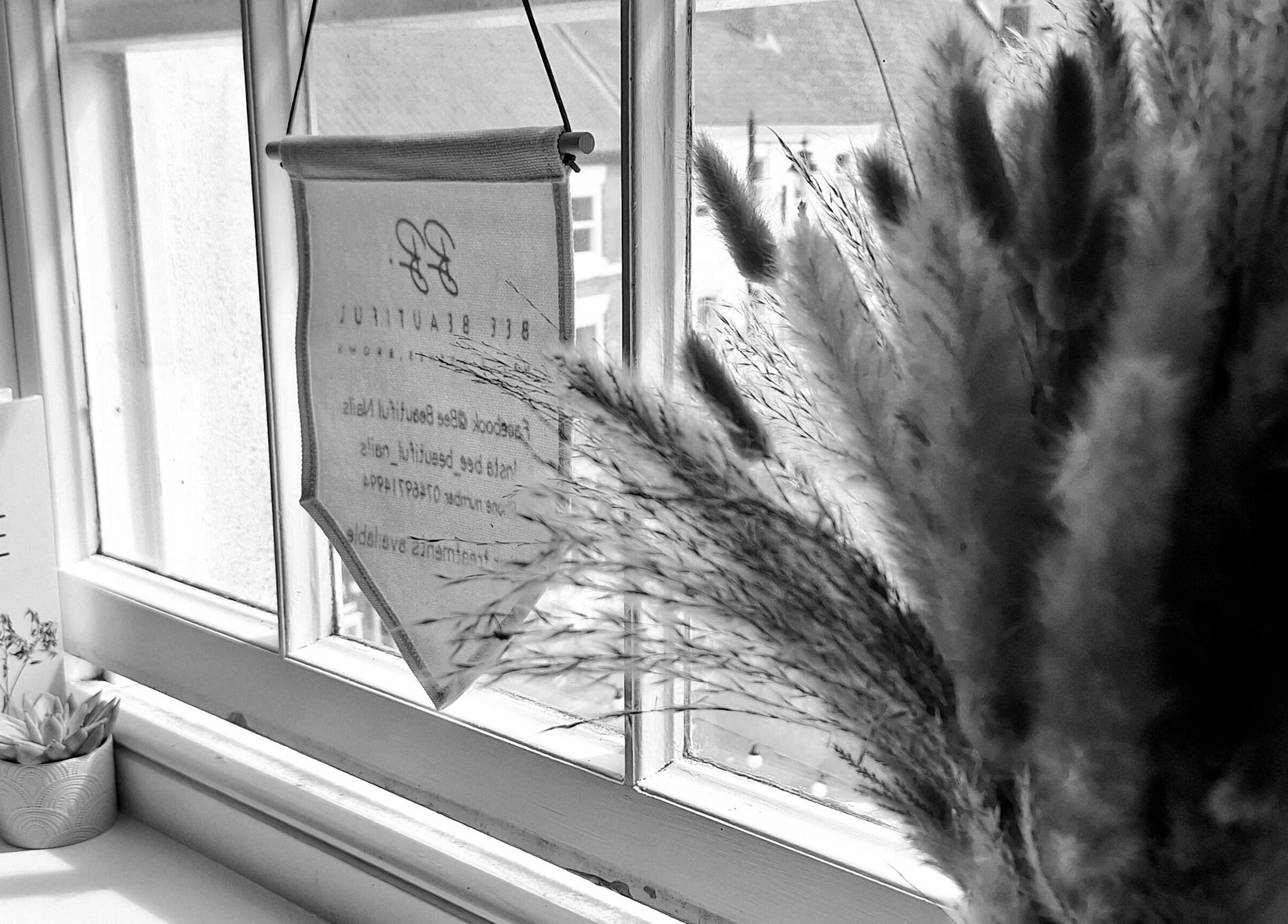 Calming window nook at Bee Beautiful, Caistor, England featuring a book and pampas grass decor.