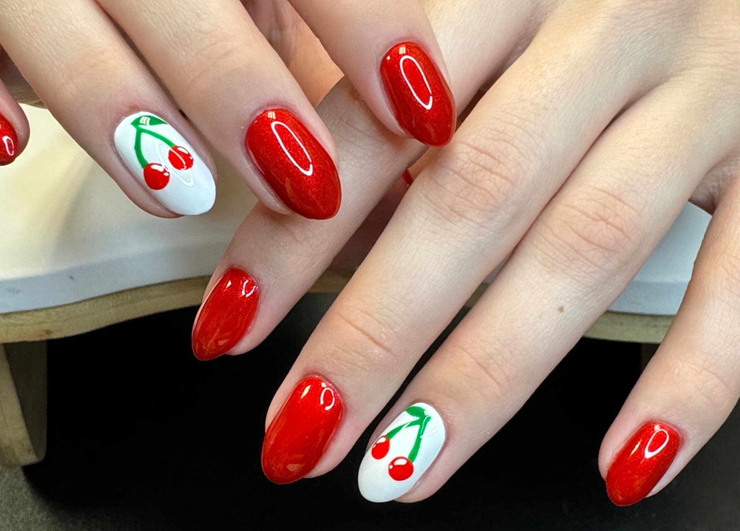 Red cherry nail art at Groovy Beauty Studio in Idaho Falls, Idaho, US. Perfect for vibrant style seekers.