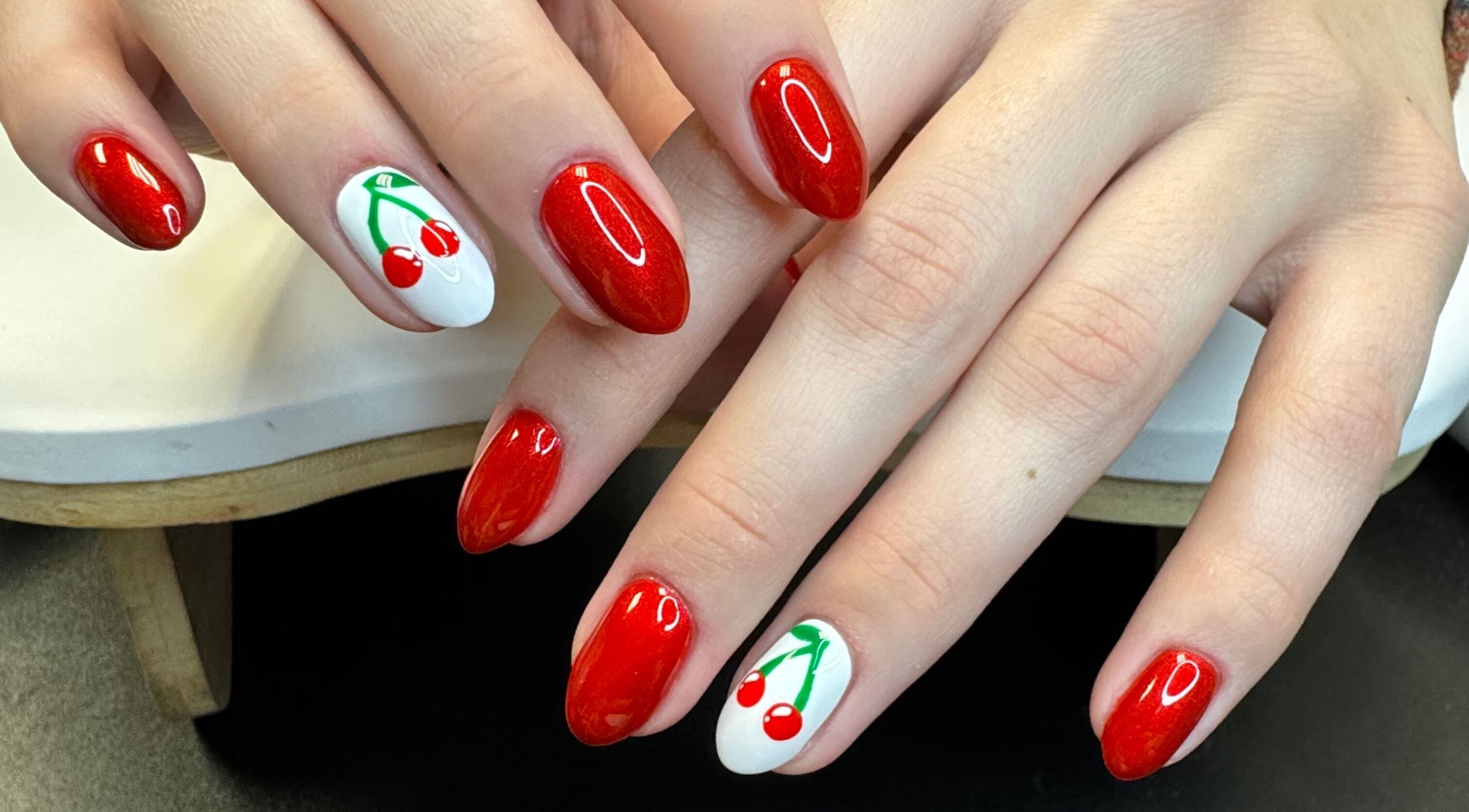 Red cherry nail art at Groovy Beauty Studio in Idaho Falls, Idaho, US. Perfect for vibrant style seekers.