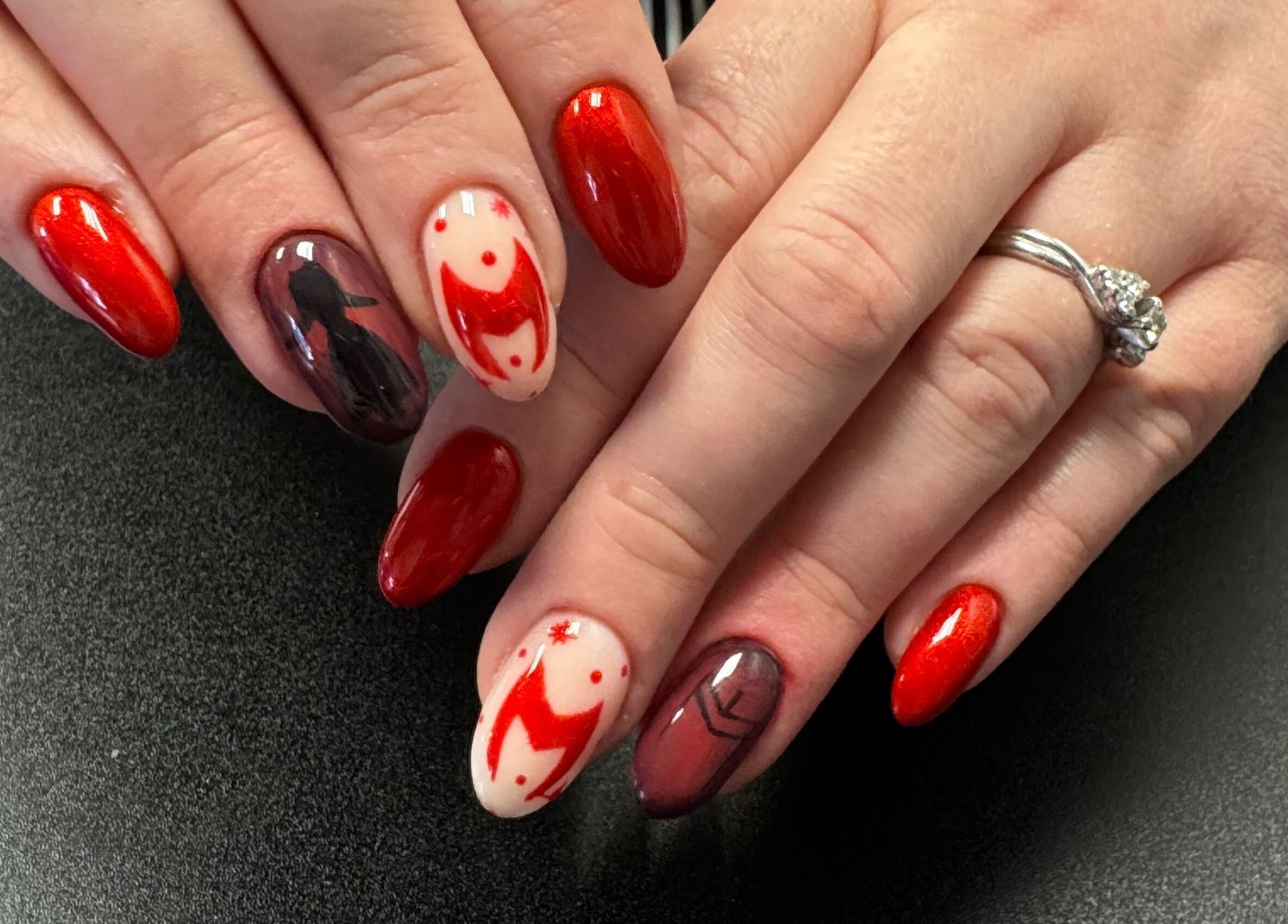 Nail art with red hues at Groovy Beauty Studio, Idaho Falls, Idaho, US. Elegant manicure design.