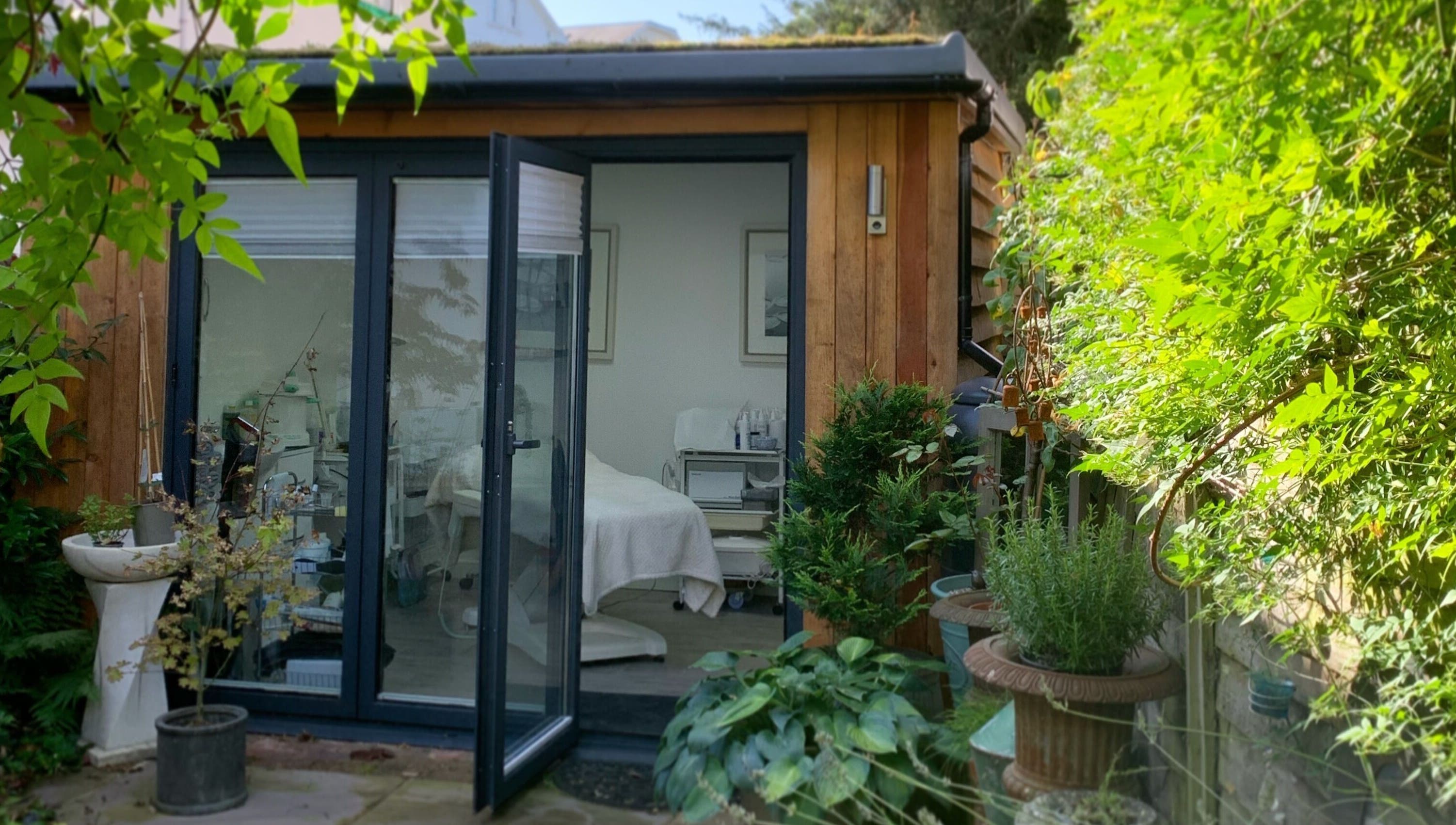 Inviting exterior view of Blooms Lash Studio, Royal Tunbridge Wells, England, GB amid lush greenery.