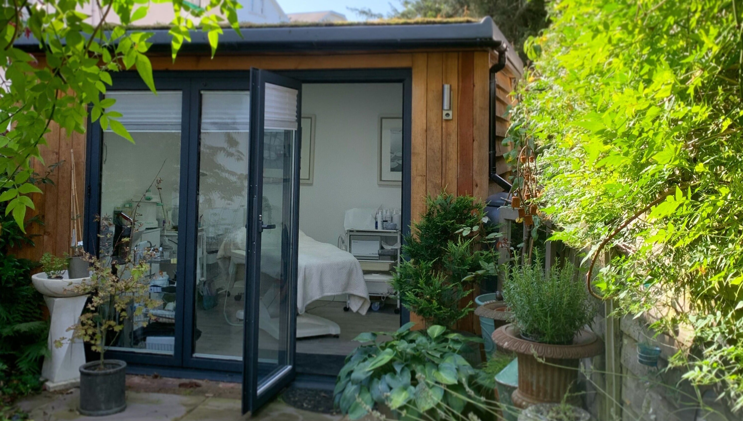 Inviting exterior view of Blooms Lash Studio, Royal Tunbridge Wells, England, GB amid lush greenery.