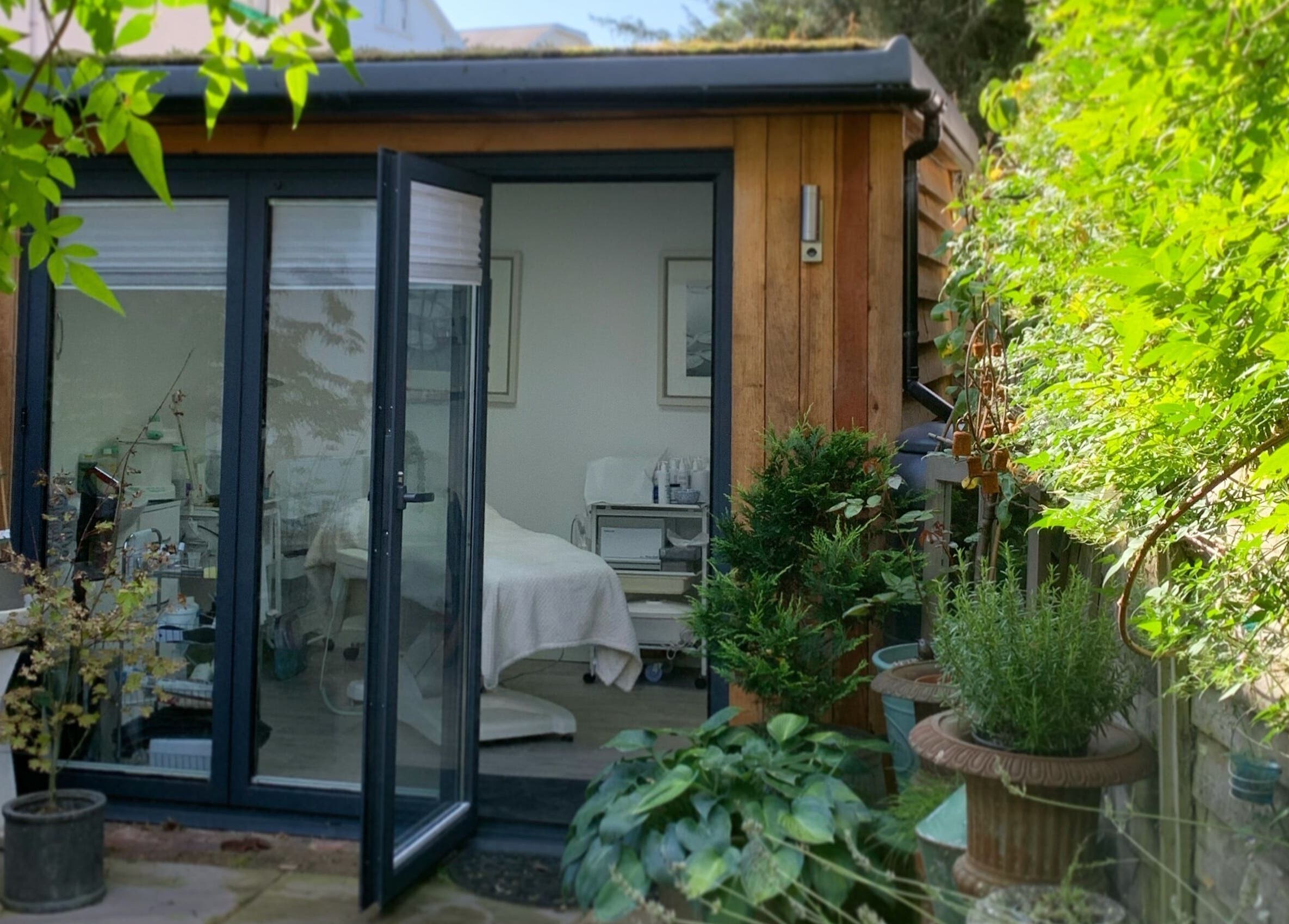 Inviting exterior view of Blooms Lash Studio, Royal Tunbridge Wells, England, GB amid lush greenery.