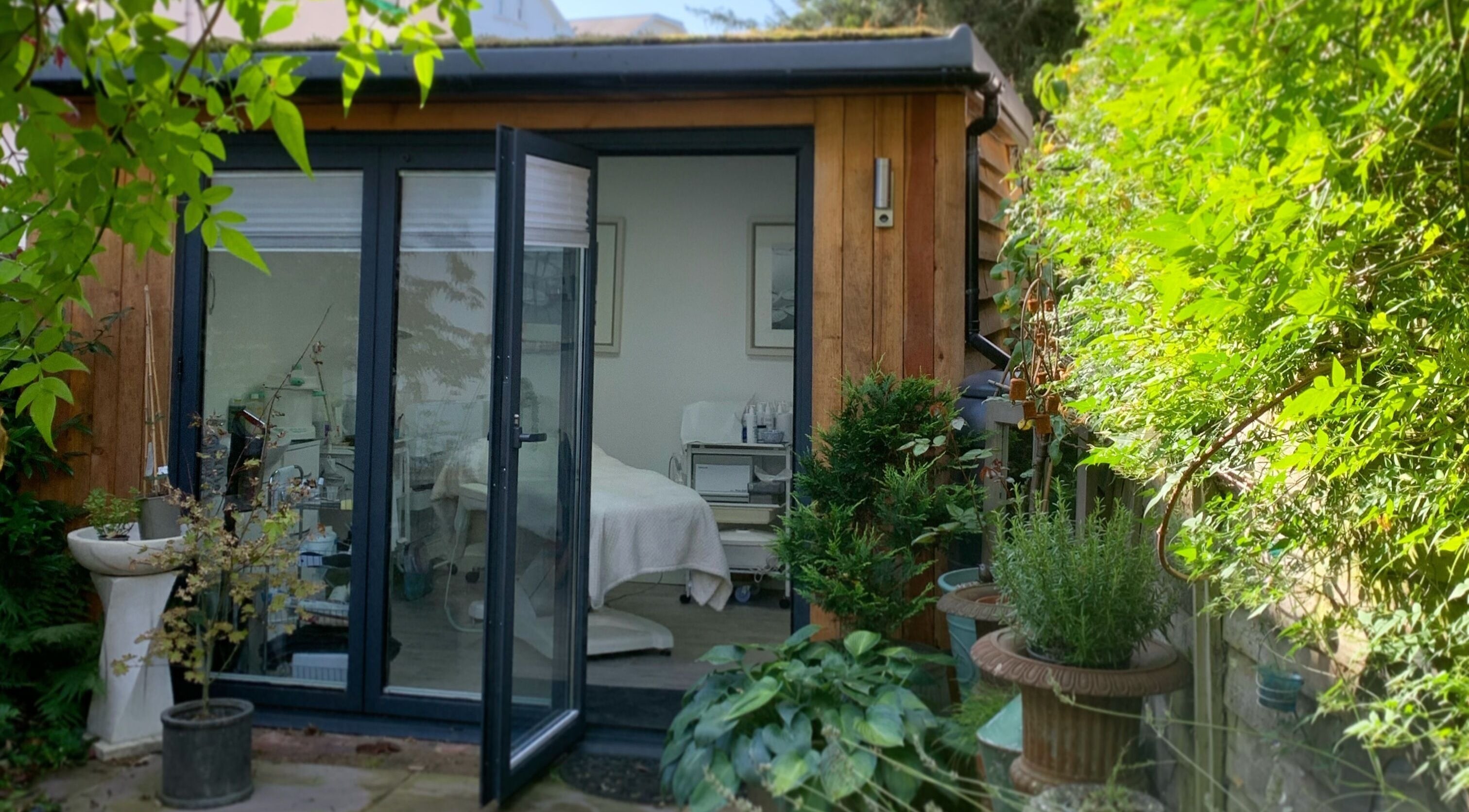 Inviting exterior view of Blooms Lash Studio, Royal Tunbridge Wells, England, GB amid lush greenery.