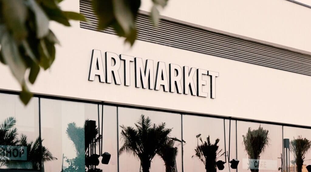 Exterior of Artmarket at Section Yas Bay, Abu Dhabi, AE with reflective glass and palm shadows.