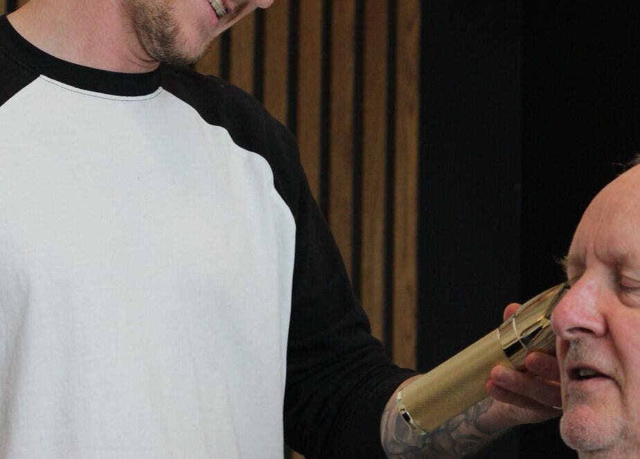 A barber trims a man's hair at Section Yas Bay, Abu Dhabi, AE, enhancing his grooming experience.