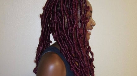 Side view of vibrant red locs styled at Isl Hair Care in Lawrence, Kansas, US.