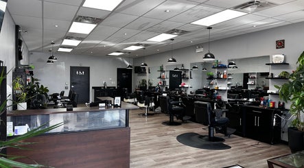 The modern interior of Yonan's Barber Shop in Hamilton, Ontario, CA, featuring sleek chairs and a well-lit ambiance.