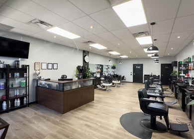 Interior of Yonan's Barber Shop, Hamilton, Ontario, CA featuring sleek, modern styling stations and product shelves.