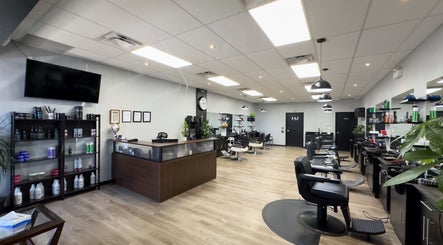 Interior of Yonan's Barber Shop, Hamilton, Ontario, CA featuring sleek, modern styling stations and product shelves.