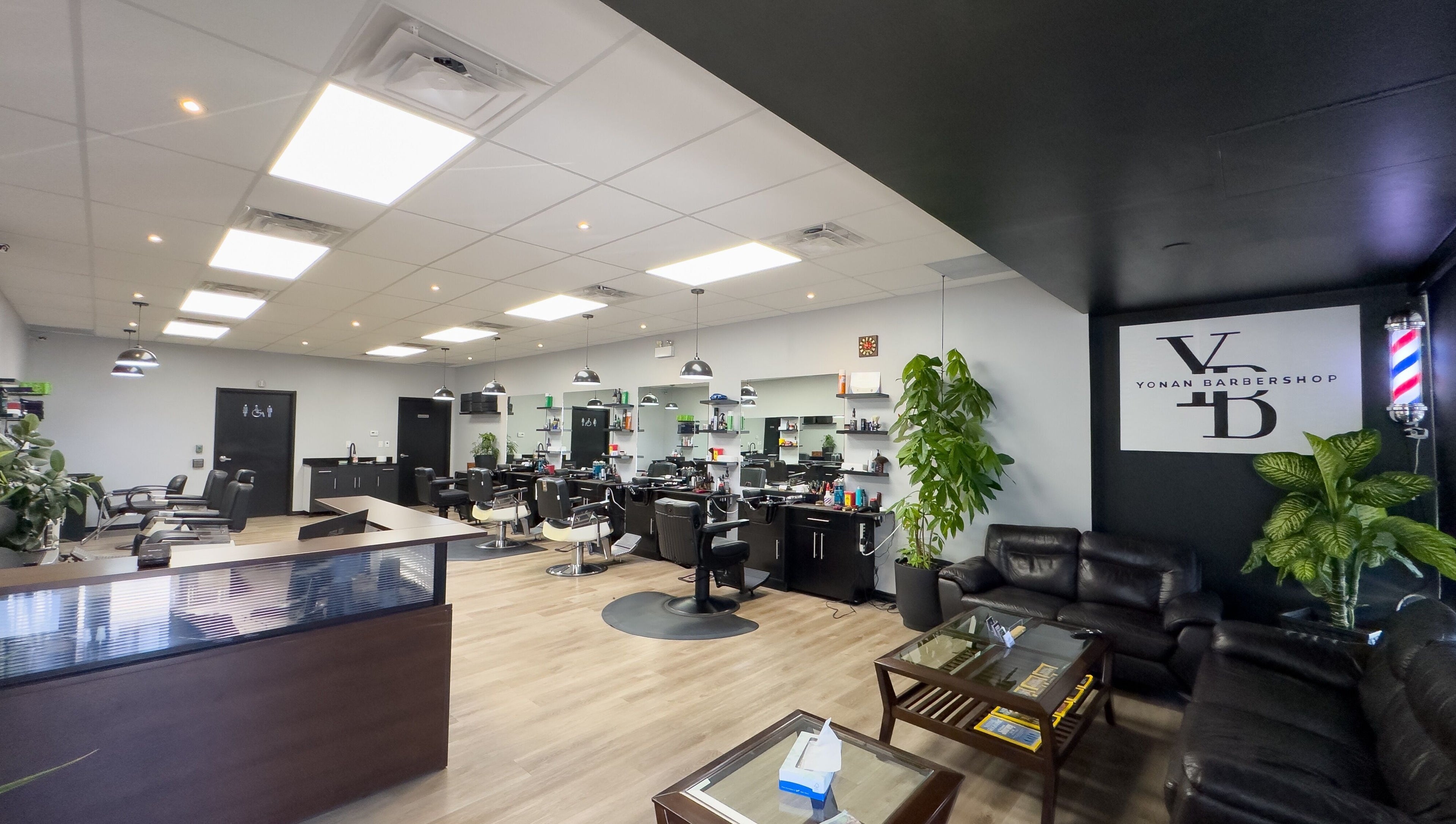 Spacious and modern interior of Yonan's Barber Shop in Hamilton, Ontario, CA with stylish chairs and decor.