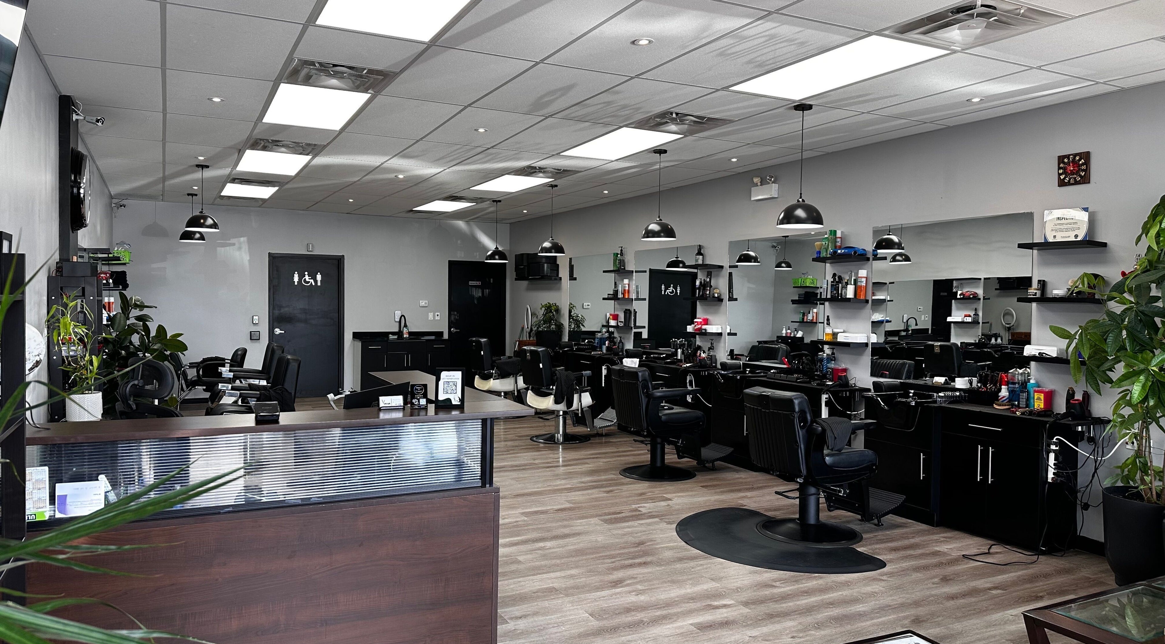 Bright interior of Yonan's Barber Shop in Hamilton, Ontario, CA, featuring sleek black chairs and contemporary decor.