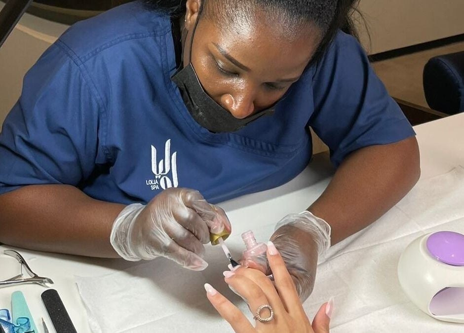 Nail technician at Lolia Salon and Spa in Riyadh, Riyadh Province, SA, applying nail polish.