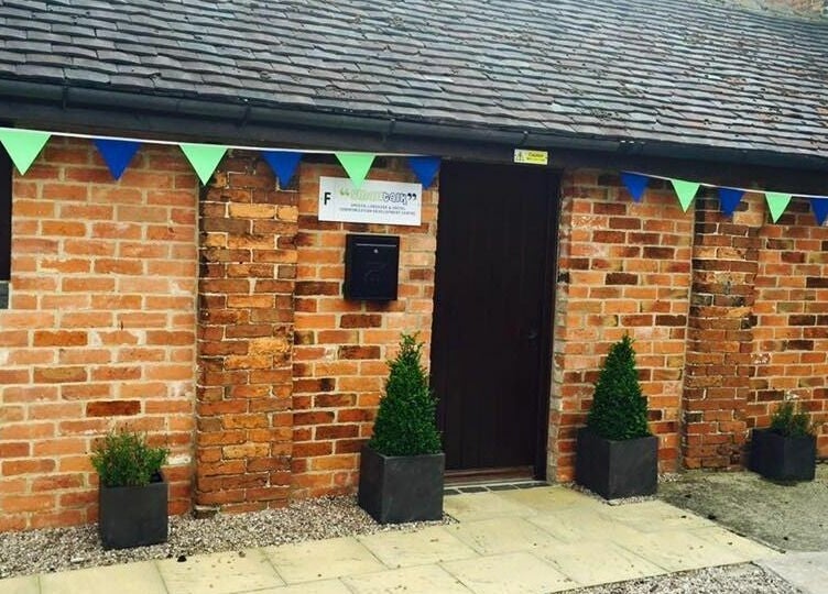 Charming entrance of Small Talk Speech and Language Therapy, Derby, England with brick facade and colorful bunting.