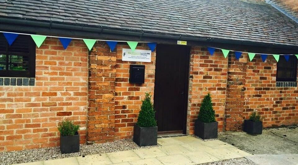 Charming entrance of Small Talk Speech and Language Therapy, Derby, England with brick facade and colorful bunting.