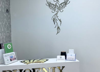 Reception desk at Phoenix Beauty By Marianna Ori, Wirral, England, GB, adorned with brochures and elegant decor.