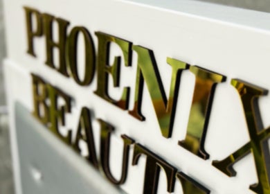 Phoenix Beauty By Marianna Ori sign in Wirral, England, GB, featuring sleek golden letters on a white background.