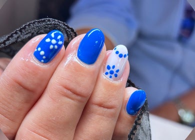 Vibrant blue nail art with floral designs at Phoenix Beauty By Marianna Ori, Wirral, England, GB.