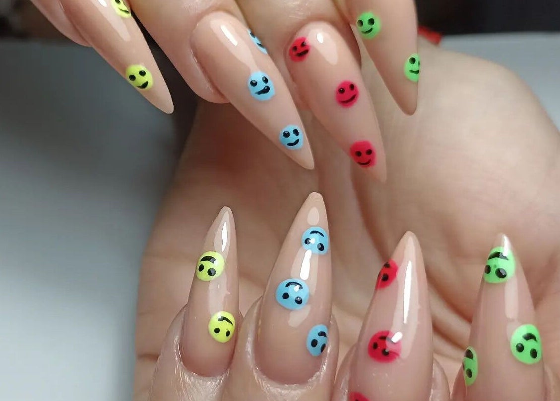 Uñas acrílicas con diseños de caras sonrientes en Helen Nails, Barcelona, Catalunya, ES.
