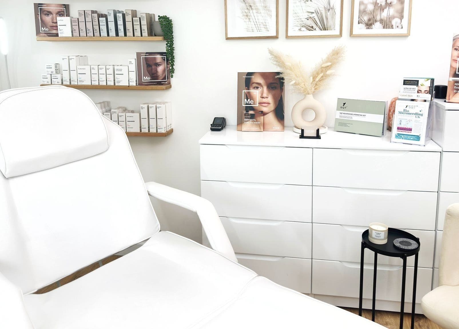Modern treatment room at The Good Skin Clinic, Peterborough, England with a white chair and skincare products.