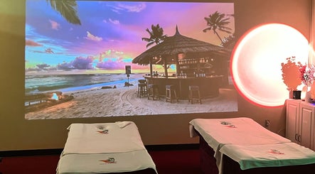 Relaxing massage beds at Ten Toes Reflexology, Lawrence, Kansas, US, with beach sunset projection.