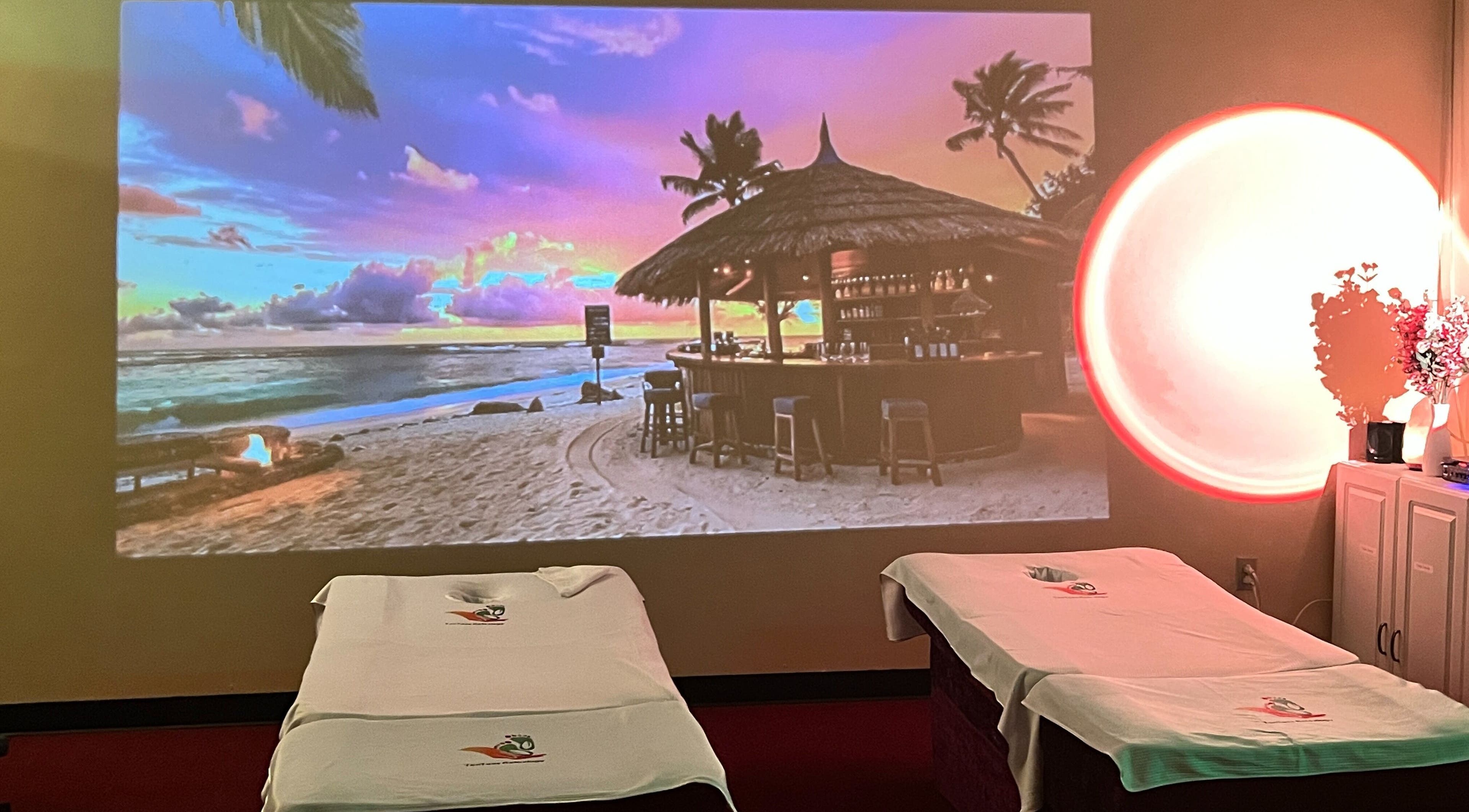 Relaxing massage beds at Ten Toes Reflexology, Lawrence, Kansas, US, with beach sunset projection.