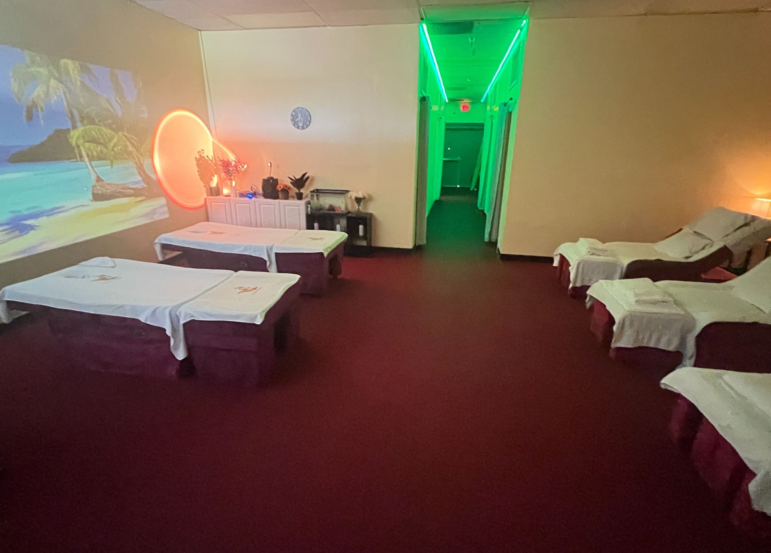 Relaxing massage room at Ten Toes Reflexology, Lawrence, Kansas, US with soothing ocean mural and ambient lighting.